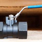 Carbon Steel Black ball valve with a blue handle positioned on a wooden surface