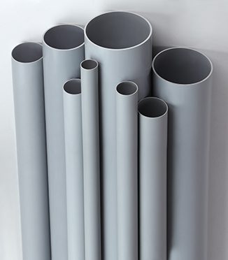 Assorted CPVC pipe sizes for plumbing on a gray background
