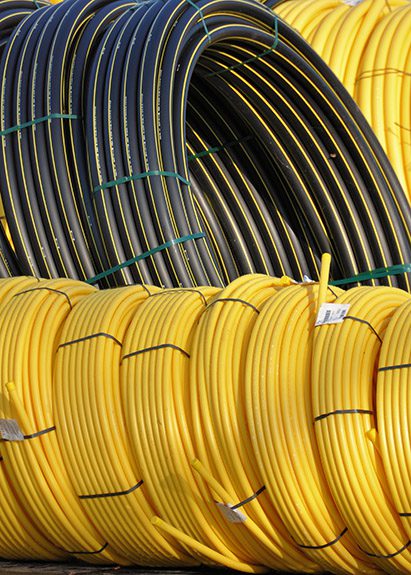 Assorted plastic pipe sizes in yellow and black for construction.