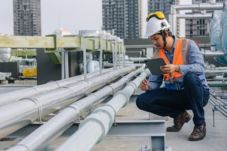 Technician inspecting steel pipes