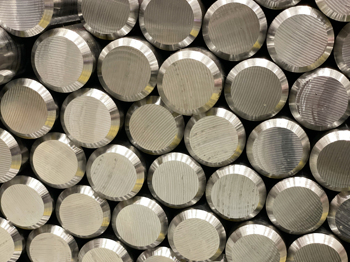 Stacked metal rods with a polished, textured surface, creating a geometric industrial pattern.